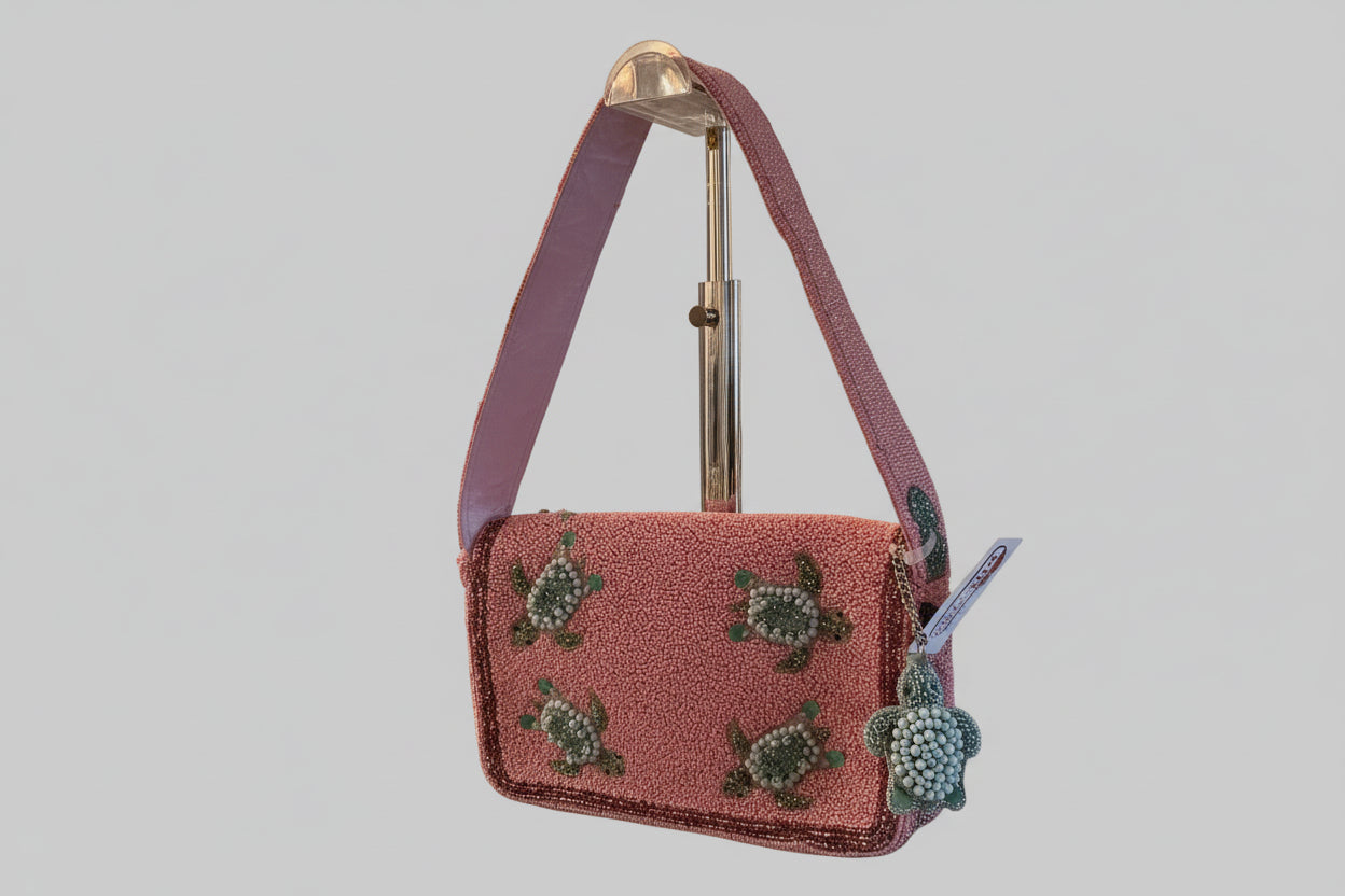 Pink beaded handbag with turtle design on a kitchen counter