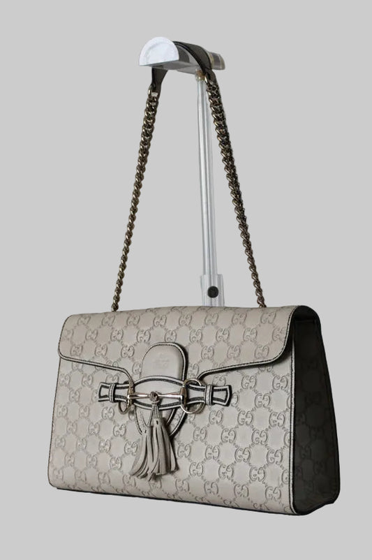 Gucci handbag with chain strap on a gray background