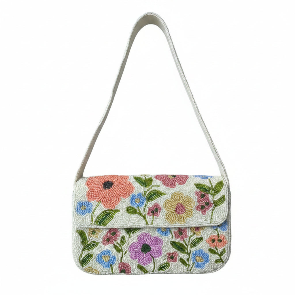 A small floral shoulder bag with a white strap and a multicolor print of pink, blue, and purple flowers on a white background, shown against a white backdrop with black letterboxing.