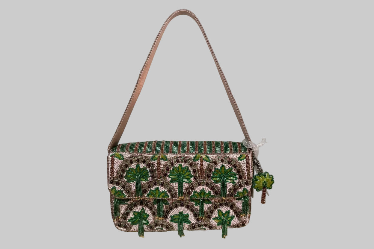 Handbag with green palm tree leaf pattern on a white background