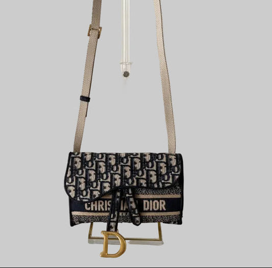 Dior navy/cream slim belt bag/crossbody with visible brand logo on a gray background
