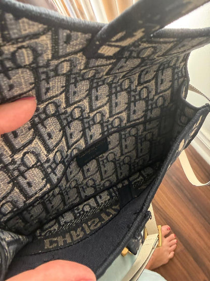 Close-up of a handbag with a patterned interior, held by a person.
