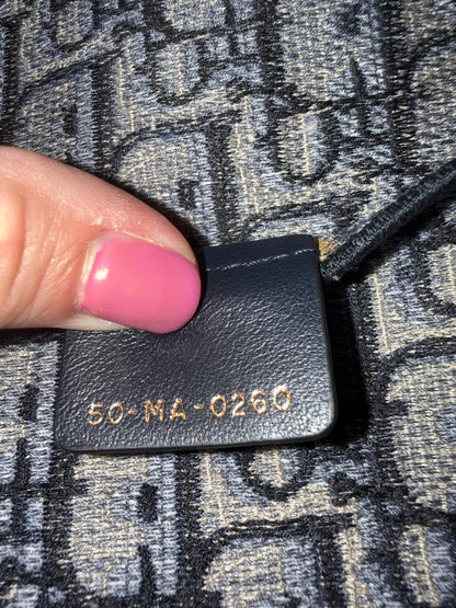 Black leather tag with gold text on a textured fabric background