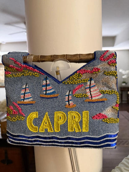 Decorative handbag with 'Capri' text and sailboat designs on a mannequin.