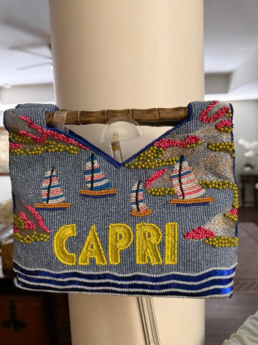 Decorative handbag with 'Capri' text and sailboat designs on a mannequin.