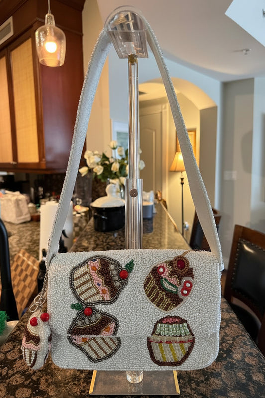 Handbag with cupcake design on a stand in a room setting
