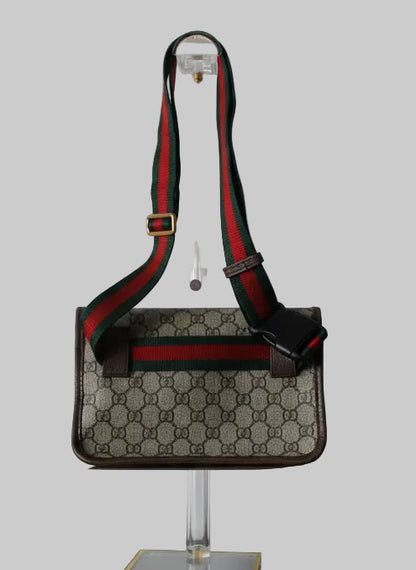 Gucci belt bag  with a distinctive strap on a gray background