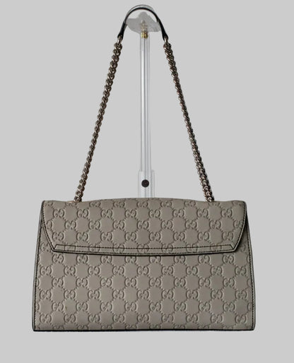 Gucci Gray handbag with chain strap on a gray background