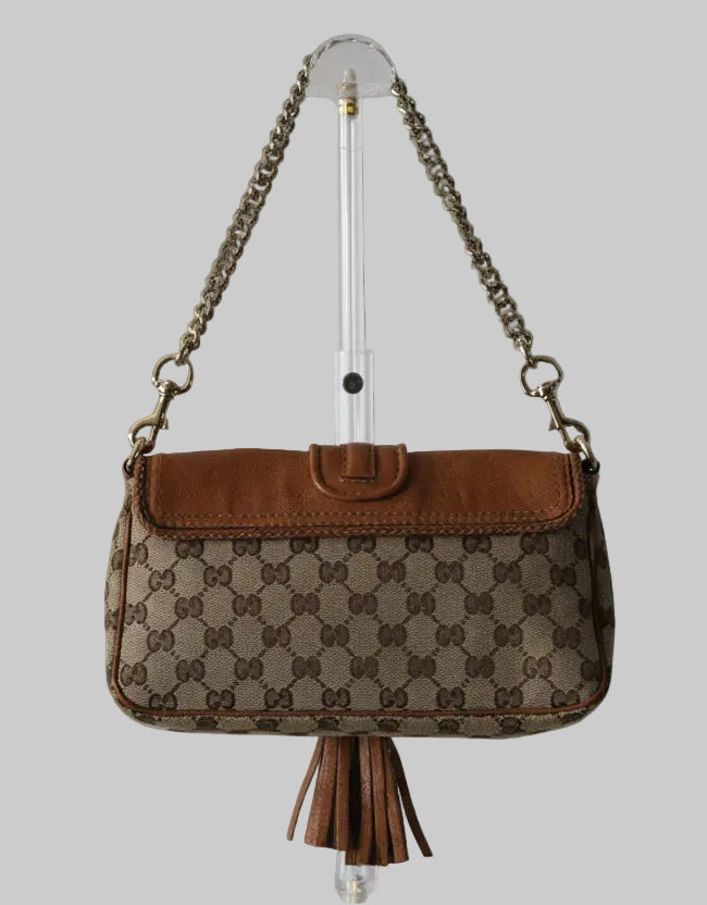Brown patterned handbag with chain strap on a gray background