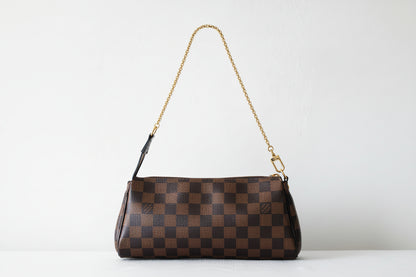 Brown checkered handbag with a chain strap on a light gray background