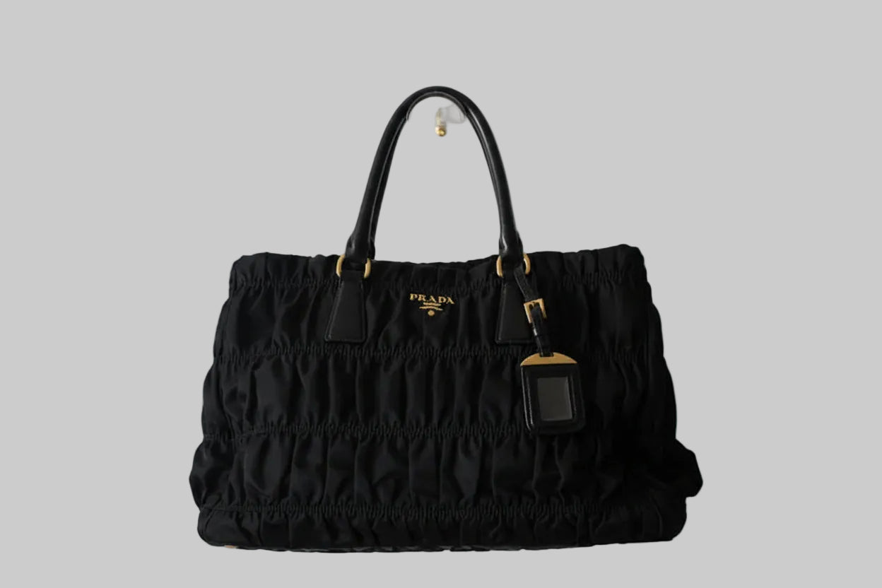 Black Prada handbag on a gray background