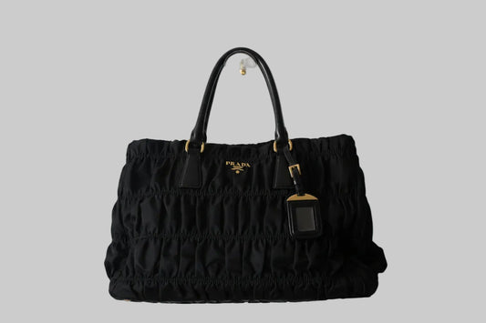 Black Prada handbag on a gray background