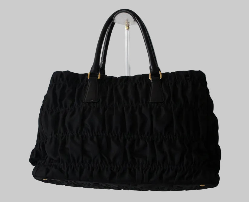 Black textured handbag on a light gray background