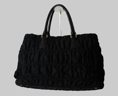 Black textured handbag on a light gray background