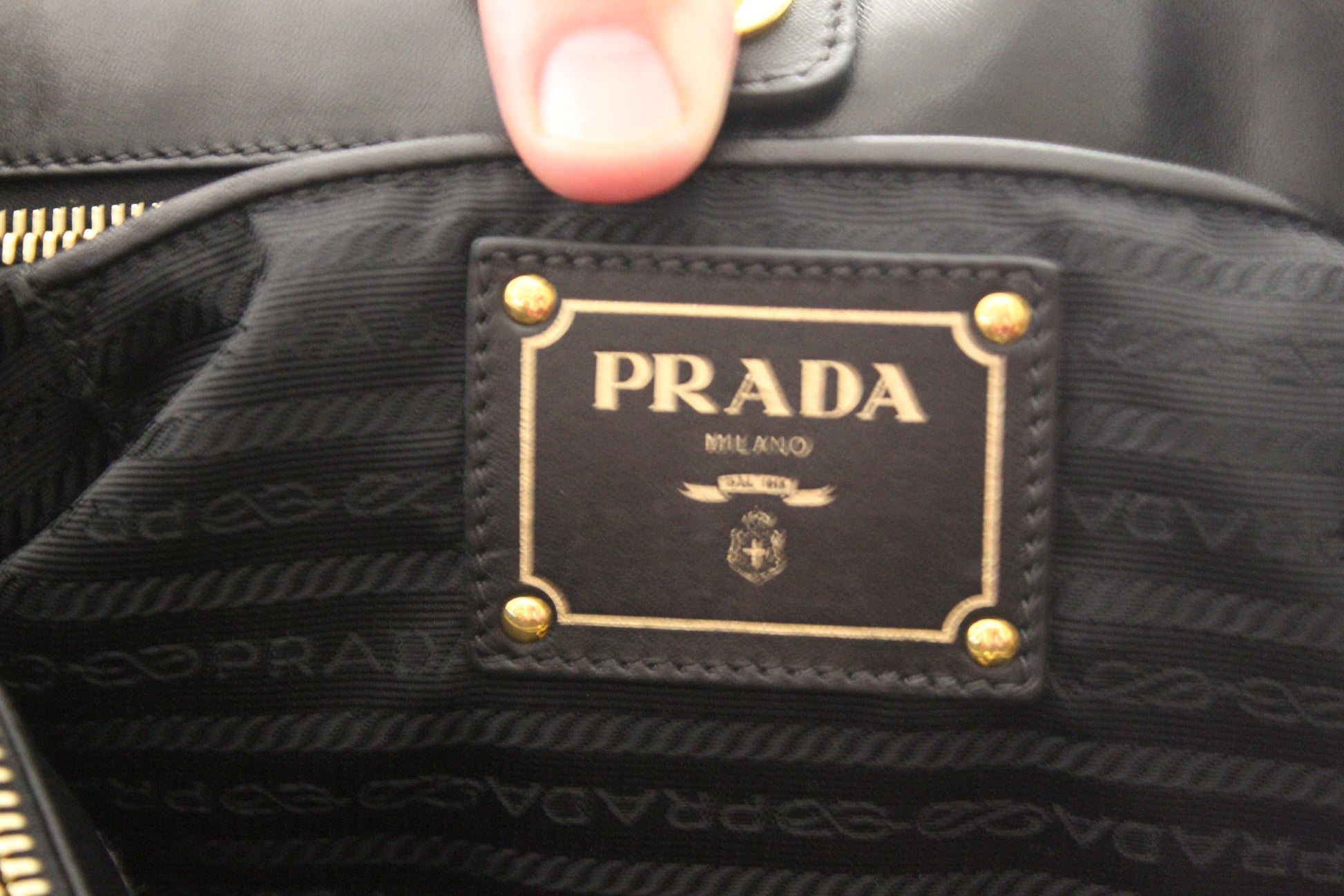 Prada label on a black textured surface