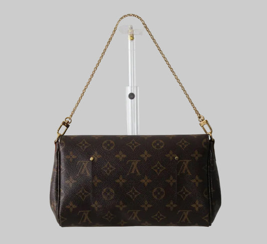 Brown handbag with gold chain strap on a gray background