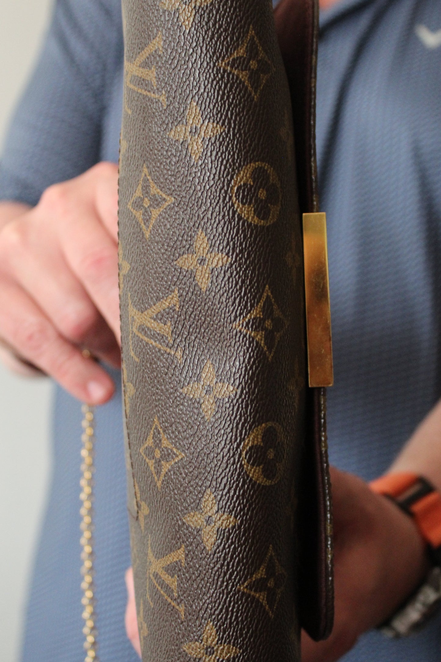 Louis Vuitton wallet held by a person with a blurred background