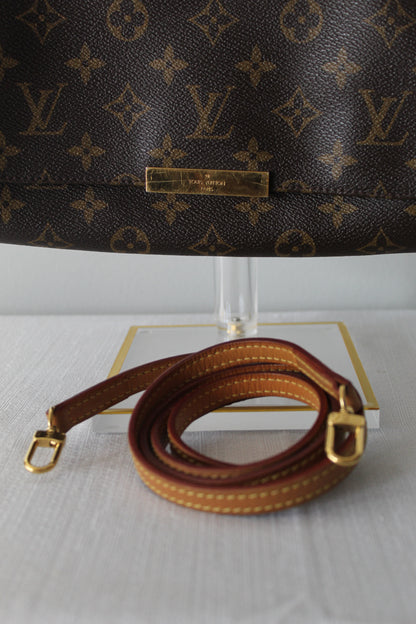 Louis Vuitton monogram handbag with brown leather strap on a white background