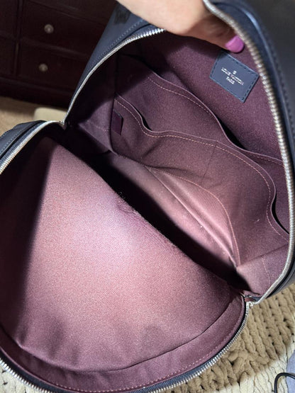 Purple garment inside a suitcase with a visible brand label.