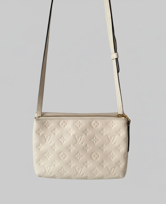 White/Cream monogram handbag with a strap on a light gray background