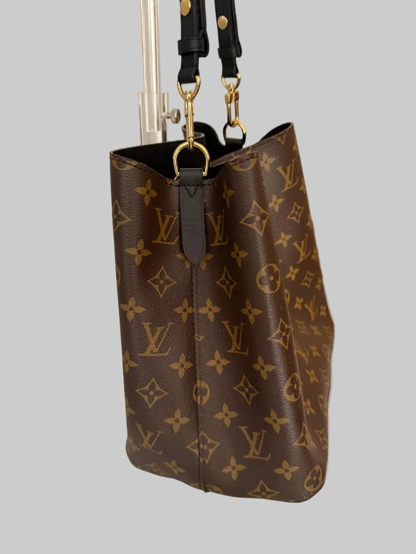 Brown monogram handbag with gold hardware on a light gray background