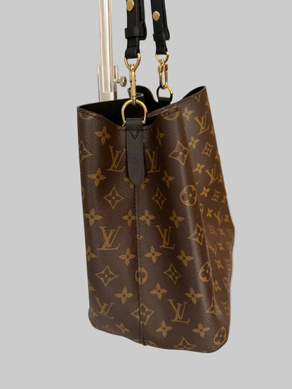 Brown monogram handbag with gold hardware on a light gray background