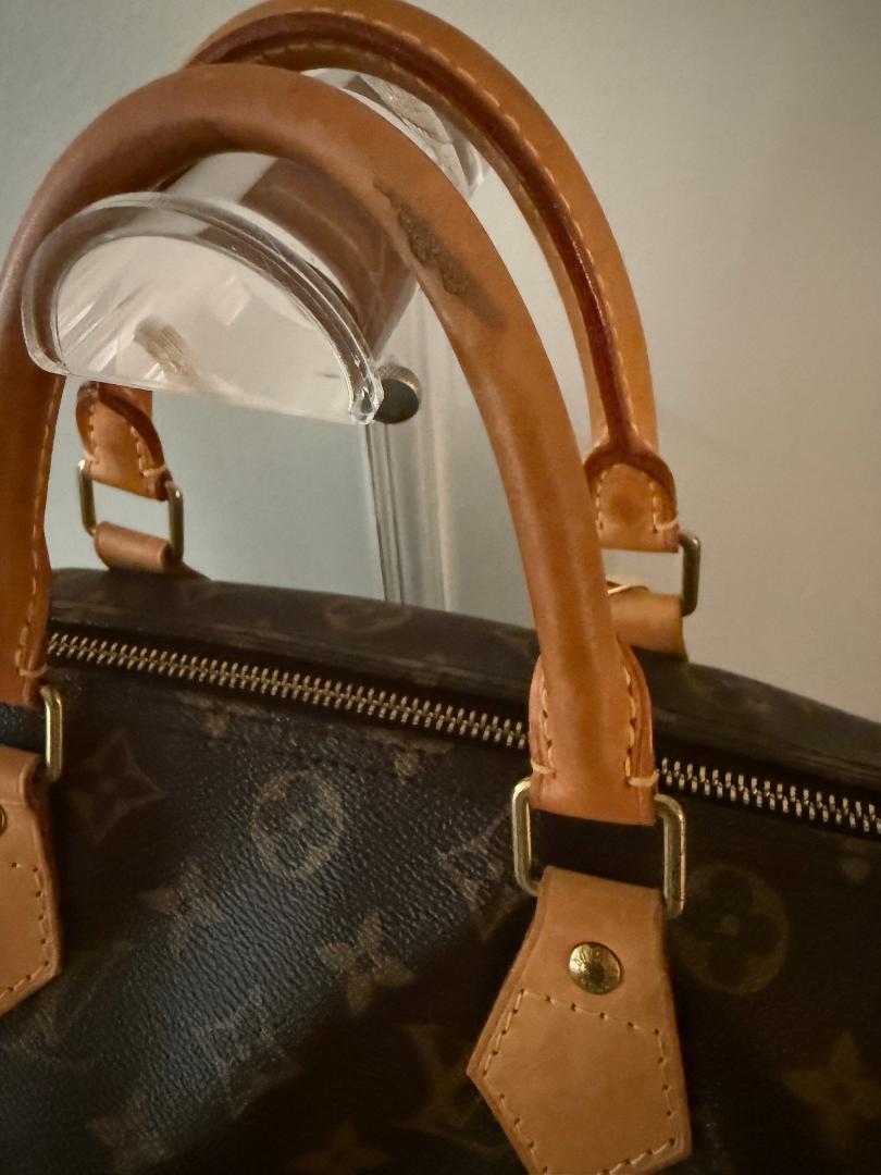 Close-up of a brown monogram leather Louis Vuitton Speedy 25 leather handles 