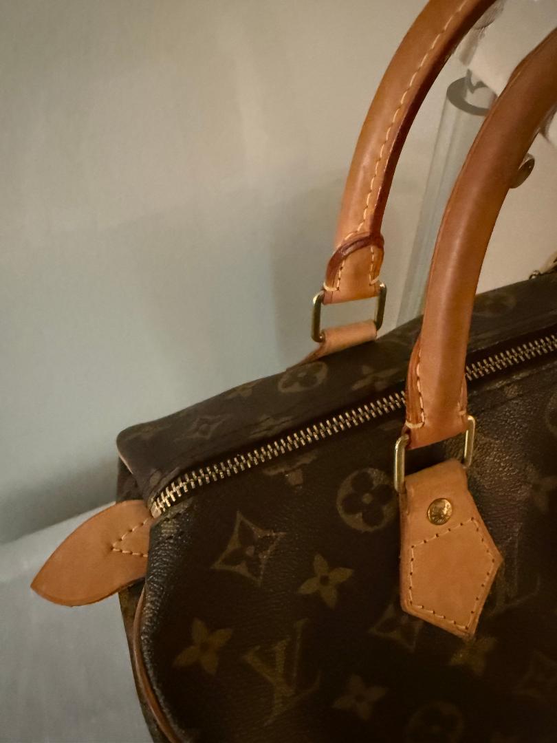 Brown leather handbag with visible brand logo on a neutral background