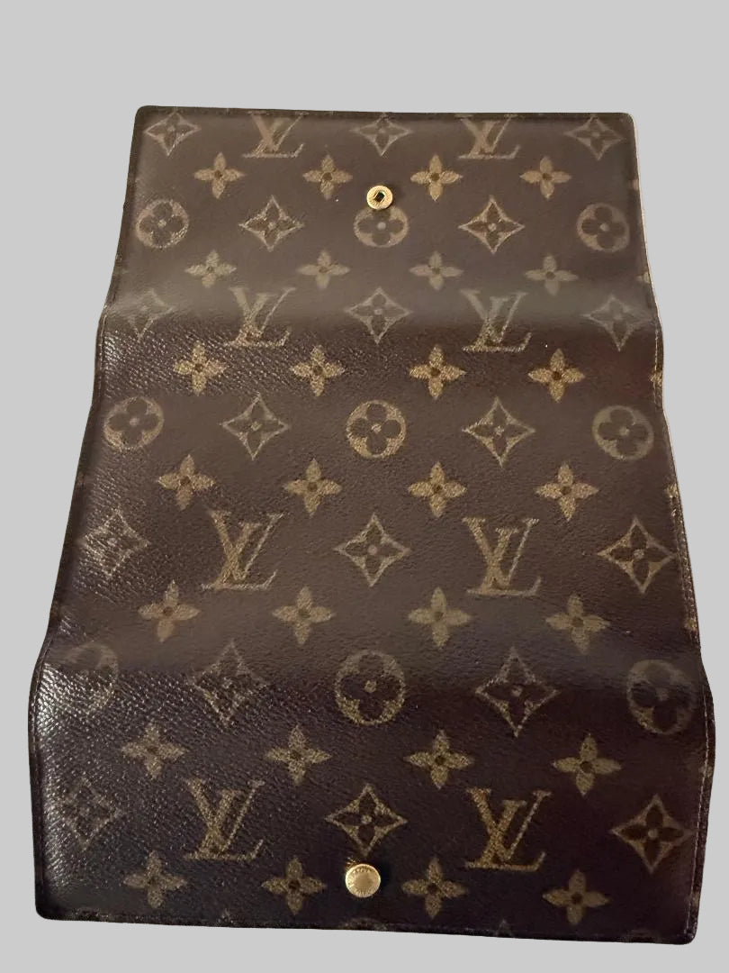 Louis Vuitton monogram wallet with coin purse on a gray background
