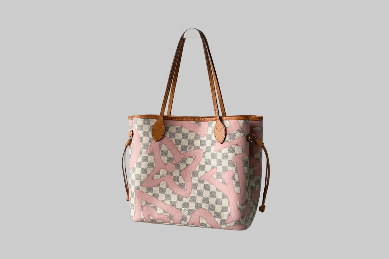 Designer handbag with checkered pattern and pink abstract design on a gray background