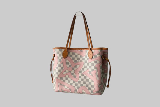 Designer handbag with checkered pattern and pink abstract design on a gray background
