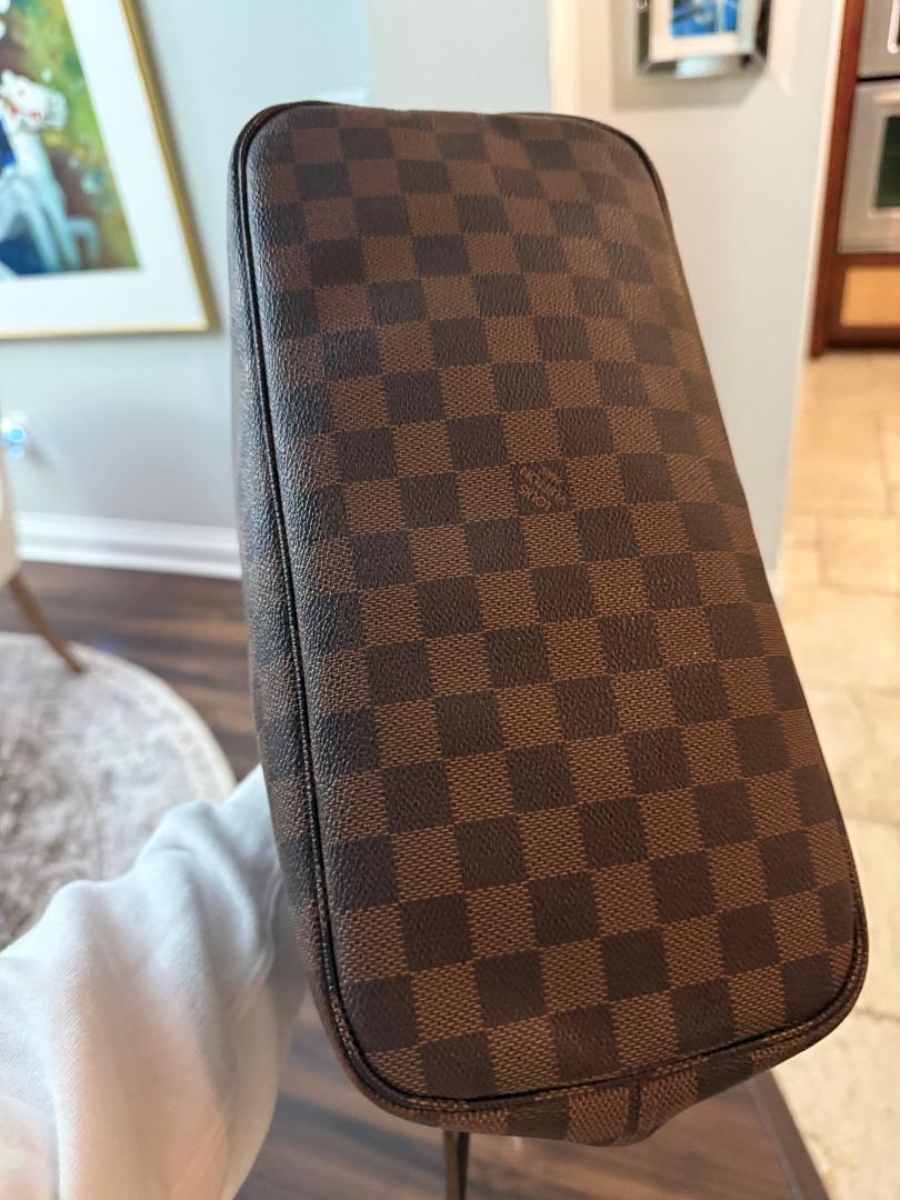 Brown checkered pouch held by a person indoors