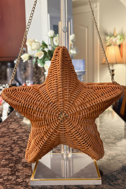 Star-shaped wicker basket on a stand with a blurred indoor background
