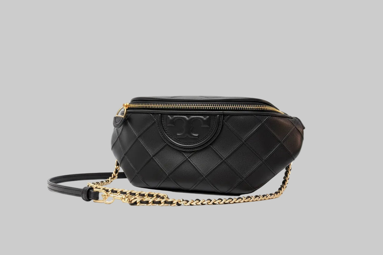 Tory Burch Black quilted crossbody/handbag with gold chain on a gray background