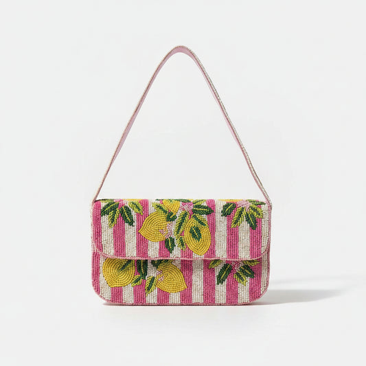 A small rectangular handbag with a pink and white striped body, decorated with yellow and green beaded lemon motifs, featuring a pink shoulder strap.