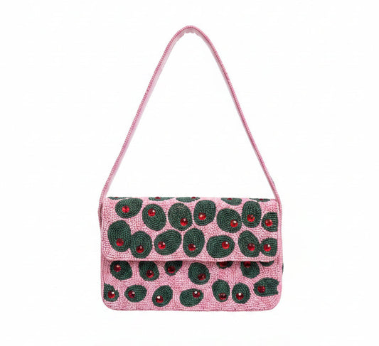 A pink beaded shoulder bag with a flap closure, decorated with a pattern of green olives. The bag has a thin pink strap and is shown against a plain white background with a soft drop shadow.